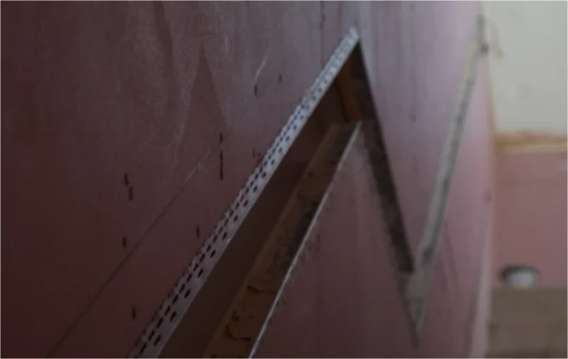 This image depicts a stairwell covered in fireproof plaster board which is being prepared for plastering.