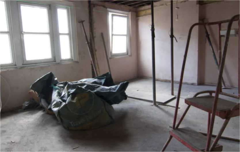 This image depicts a room with Victorian style windows under construction with temporary steel columns holding up the roof timbers.