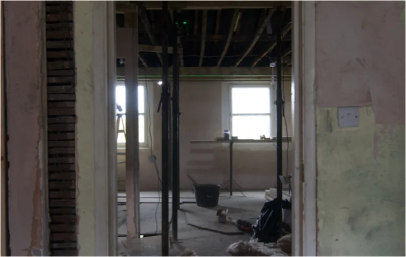 This image depicts a larger room which has had it's walls demolished and being prepared for new walls to go up.